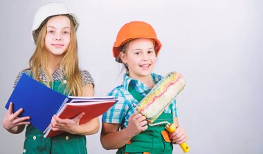 Tablet ve rulo ile kask küçük çocuklar. İşçi bayramı. 1 mayıs. küçük kızlar atölyede birlikte tamir. Foreman müfettişi. Onarım. okul projesi. başarılı bir takım. başarılı iş