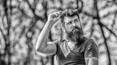 Yakışıklı adamın kendine güvenen duruşu. Adam çekici sakallı hipster açık havada poz. Uzun sakallı erkeksi bir görünüm. Berber konsepti. Sakal tımarı. Sakal bakımı. Erkeklik ve erkeklik