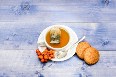 Sağlık hizmetleri kocakarı ilaçları. Aromatik rowanberry içeceği için. Mavi arka planda bir fincan çay yakın plan. Lezzetli gurme tadı. Kafe menüsü. Böğürtlen çayı. Seramik fincan sıcak demlenmiş çay içeceği.