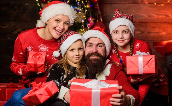 Kerstvreugde. Kersttraditie. Fijne feestdagen. Ouders en kinderen openen kerstcadeaus. Vrolijk familieconcept. Vader Kerstman en moeder kleine dochters kerstboom achtergrond — Stockfoto