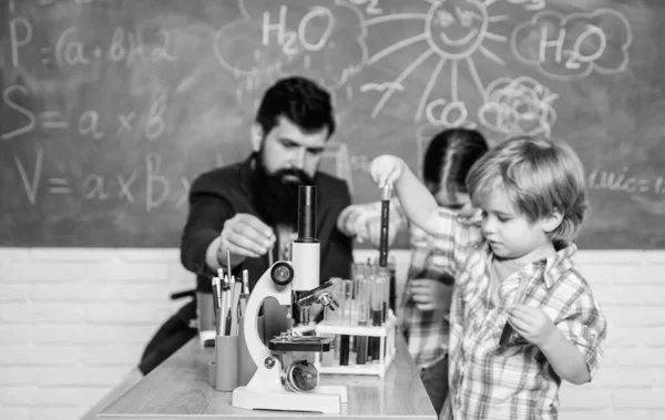 Δάσκαλος και μαθητές με δοκιμαστικούς σωλήνες στην τάξη. Ενδιαφέρουσες σχολικές τάξεις. Σχολική εκπαίδευση. Πείραμα χημείας του σχολείου. Σχολική λέσχη. Εξηγώντας χημεία στο παιδί. Συναρπαστική χημική αντίδραση — Φωτογραφία Αρχείου