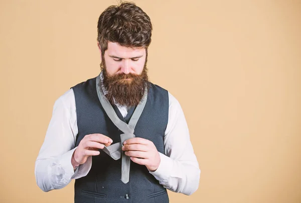 Looking classy. Elegant man. Bearded man tying a tie. Brutal caucasian man adjusting fashion accessory. Man with long beard and moustache dressing in classic style, copy space