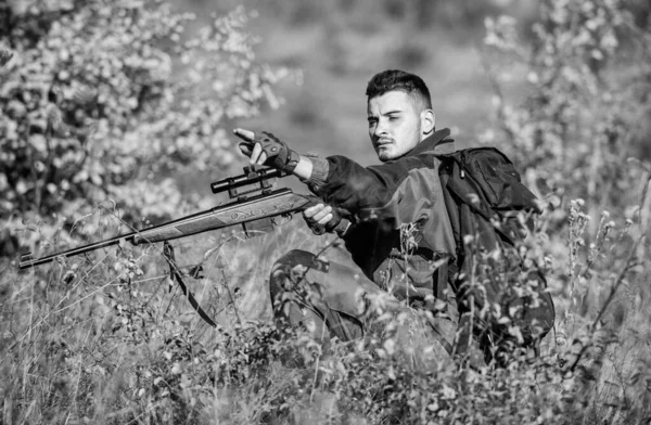 Hunter tartani puska. Vadászati engedély. Szakállas, komoly vadász költenek szabadidős vadászatot. Vadászati felszerelés szakembereknek. Vadászat brutális férfi hobbi. Ember hord álcázási ruhát természet háttér — Stock Fotó