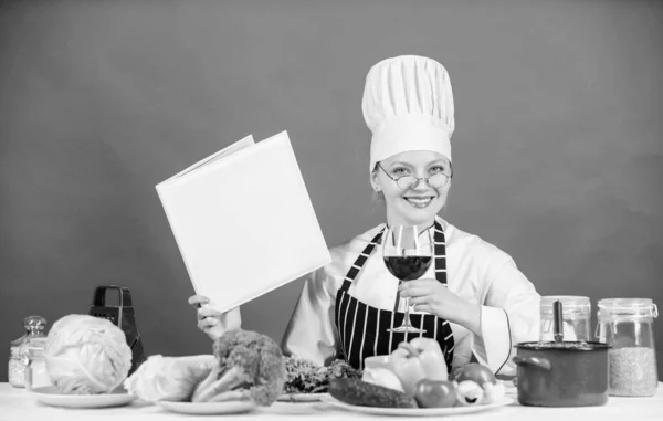 Traditional cuisine. Culinary school concept. Female in hat and apron knows everything about culinary arts. Culinary expert. Woman chef cooking healthy food. Girl read book top best culinary recipes