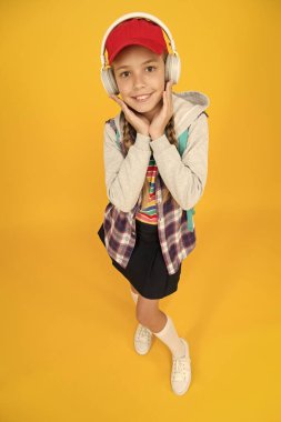 Havalı liseli. Gençlik modası. Neşeli bir genç. Küçük kız uzun saçlı. Ergen yaşam tarzı. Okul günleri. Modern bir genç. Mutlu bir çocukluk. Sevimli hippi ergen çocuk sarı arka plan