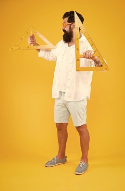 Adam matematik dersi. Ölçme aleti kullanan öğrenci. Mühendislik mimarlık fakültesi öğrencisi. Akıllı öğrenci. Üniversite eğitimi. Üçgenli sakallı. Özellikleri keşfetme