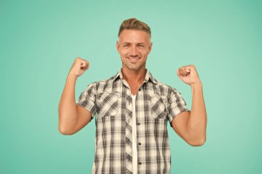 Sıradan ve güçlü. Güçlü adam kollarını mavi arka planda açar. Sıradan tarzda yakışıklı bir adam. Sıradan moda trendleri. Moda ve tarz. Rahat hissediyorum. Sıradan görünüş