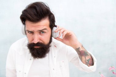Kulaklık takan sakallı adam. Erkek telsiz operatörü. Müzik dinleyen bir adam. - Seni duyamıyorum. kopyalama alanı. Nitel müzik aleti. Gürültü kesme fonksiyonu. çevrimiçi eğitim
