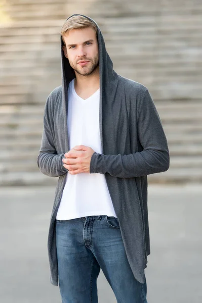 Comfortable clothes daily wear. Great taste to dress well. Male fashion influencer. Fashionable young model man. Street style outfit. Handsome man with hood standing urban background. Fashion trend