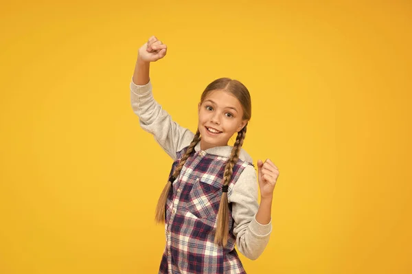 En humor lúdico. Moda infantil. niño lindo pelo rubio. felicidad infantil. Feliz día de los niños. Chaqueta a cuadros de niña pequeña. tiempo de otoño. chica hipster fondo amarillo. chica de la escuela feliz estilo casual — Foto de Stock