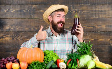 Sakallı, tahta arka planı olan bir adam. Organik bahçecilik konsepti. Organik sebzeli çiftçi. Bahçıvanlık ve tarım sistemleri belirli teknikler önerir. Organik ürünler yetiştir. Ev yapımı organik yiyecekler.