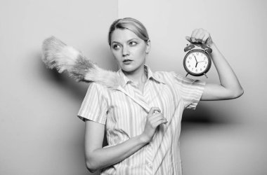 Kadın pp Duster ve çalar saat. Yorgun hizmetçi. Mükemmel temizlik servisi. Temizlik şirketi. Karısının dinlenmek için zamana ihtiyacı var. Hizmetçi zamanı yönetimi. ev idaresi kavramı