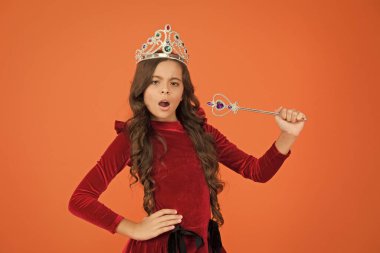 Lüks şeyleri keşfet. Şaşırmış uzun kıvırcık saçlı kız. Küçük prenses sihirli değneği tutuyor. Peri masallarındaki sihirli kraliçe. Sadece bir dilek tut. Bütün hayaller gerçek olur. Havalar ve zarafetler. kraliyet ve lüks