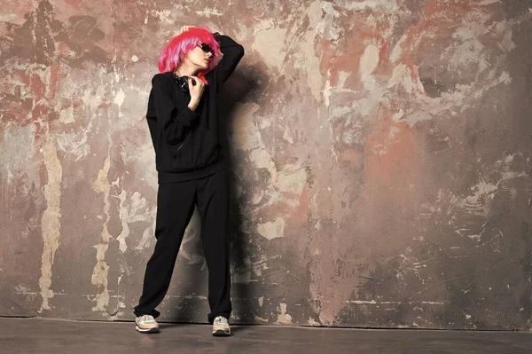 Mujer en peluca rosa pelo desgaste traje deportivo longitud completa — Foto de Stock