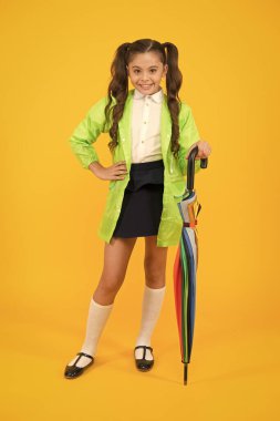 Okula gidiyorum. Suya dayanıklı kıyafetler. Korunan konsept. Yağmura dayanıklı kıyafetler. Sonbahar aksesuarı. Sonbahar havası. Tamamen hazırım. Şemsiyeli kız öğrenci su geçirmez yağmurluk giyiyor. Sonbahar yağmuru