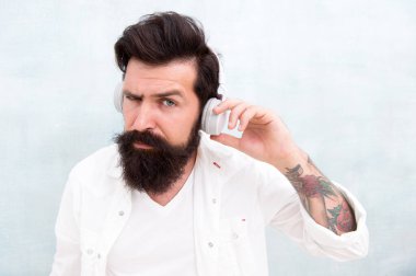 Mükemmel bir fikir. Elektronik dans müziği ve ev şarkıları. Enstrümantal müzik. Sakallı adam kulaklıkları arka planda. Hippi müzik kulaklığı dinler. Modern kablosuz kulaklıklar