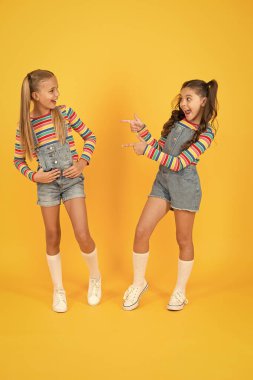 Gökkuşağı kıyafeti giyen küçük kızlar. Mutluluk. Kızlar uzun saçlı. Şirin çocuklar aynı kıyafetlerle iletişim kuruyor. En iyi arkadaşlar. Moda ve gösterişli. Duygusal çocuklar işte. Moda dükkanı. Modern moda. Çocuk modası