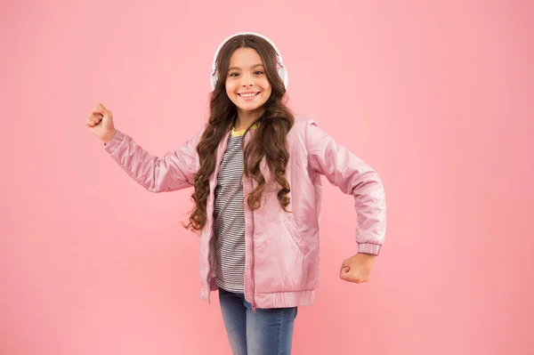 Music on. Happy child enjoy listening to sound track. Little girl wear earphones pink background. Enjoy sound. Sound vibrations. Music and technology. Audio sound. Fun and entertainment