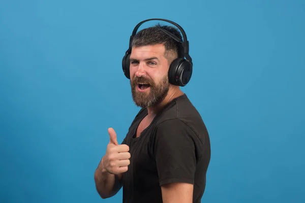 Dj with beard wears headphones. Man holds thumbs up — Stock Photo, Image