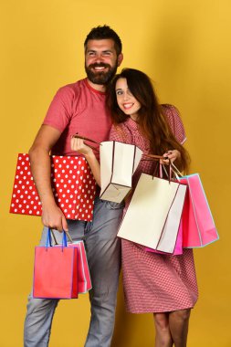 Sakallı bir adam ve gülen yüzlü bir kız alışveriş yapıyor.