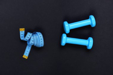 Şekil verme ve fitness ekipmanları. Mezuranın yanındaki halterler