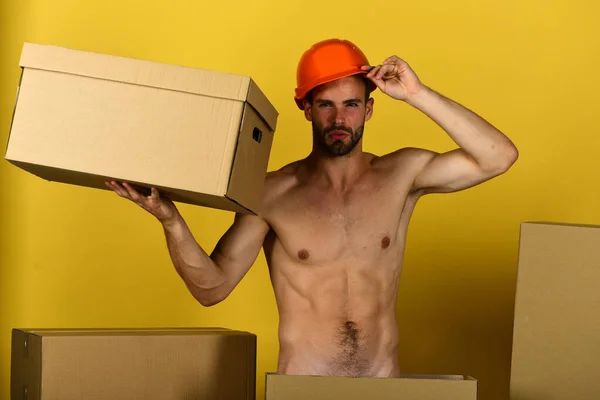 Sexualita a stavební koncept: chlap se sexy trupem drží karton — Stock fotografie