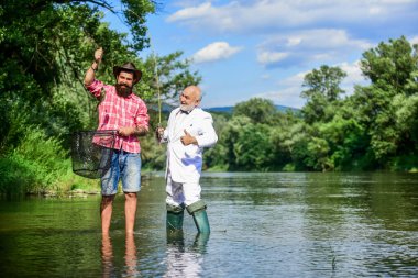 Aileyle hafta sonu. Mutlu balıkçı arkadaşlığı. İş adamının uçan balık hobisi. emeklilik balıkçılığı. İki erkek arkadaş birlikte balık tutuyor. Yakalama ve balık tutma konsepti. Emekli baba ve olgun sakallı oğul.
