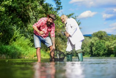 En iyi hafta sonuydu. İki erkek arkadaş birlikte balık tutuyor. Yakalama ve balık tutma konsepti. Mutlu balıkçı arkadaşlığı. Emekli baba ve olgun sakallı oğul. İş adamının uçan balık hobisi. emeklilik balıkçılığı