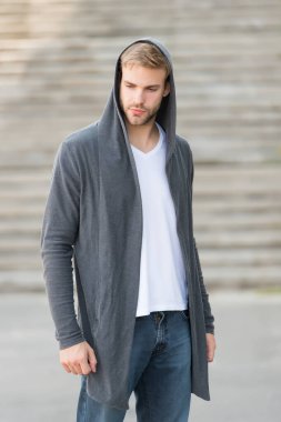 Moda modası. Günlük giysiler için rahat kıyafetler. Erkek modası etkisinde. Moda mankeni genç adam. Kapüşonlu tasasız adam sokak tarzı kıyafet. Kapüşonlu, kentte yaşayan yakışıklı bir adam.