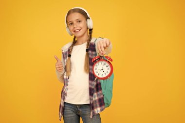 Dersler başlıyor. Okula gitme zamanı. Okul zamanı. Mutlu kız çalar saati dakikaları sayıyor. Bilgi toplama günü. Ders programı. Liseli kız alarm saatini sarı arka planda tutuyor. Okul zamanlama kavramı
