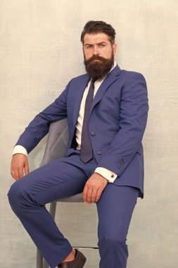 O kesinlikle etkileyecektir. Kendine güvenen bir iş adamı. İş adamı sandalyeye oturur. Resmi tarzda sakallı iş adamı. Sakallı ve bıyıklı bir iş adamı. Zeki ve profesyonel görünüm. İş elbisesi kuralı