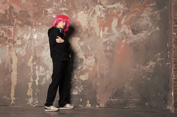 Chica en traje deportivo de longitud completa en la pared abstracta — Foto de Stock