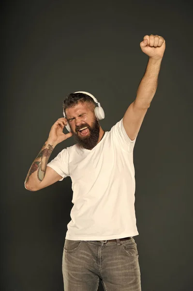 Toujours gagnant. Heureux gagnant célébrer avec de la musique. Homme barbu dans les écouteurs faire geste gagnant. Émotionnel hipster écouter de la musique fond gris. Célébrons la victoire. Gagnant n'abandonne jamais — Photo