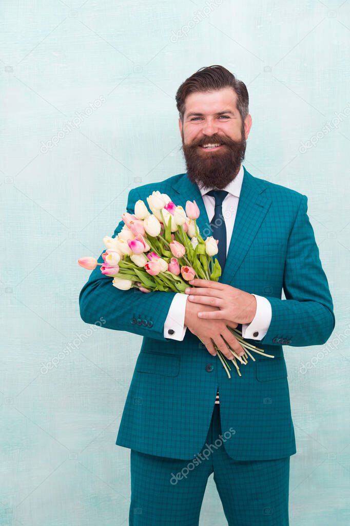 confident businessman hold flowers gift. happy man ready for love date. valentines day holiday. spring is here. for my mother at mothers day. happy womans day. celebrate birthday party