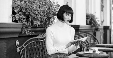 İş kadını kahve molasında kitap okurdu. Mükemmel hafta sonu için kahve ve iyi bir kitap. Kişisel gelişim konsepti. Kadınlar kafeterya terası okumaktan zevk alır. Modern kadın edebiyatı