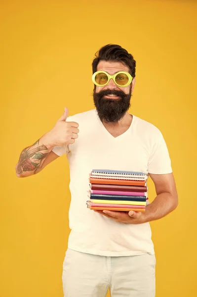 Colorful stationery. Stationery admirer. Buy sketchbooks. Hipster eccentric guy hold pile notepads. Stationery shop. Study hard. Language courses. Buy stationery. Diverse assortment office supplies