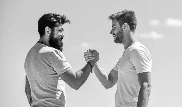 Strong and muscular arms. Successful deal handshake blue sky background. Men shaking hands at meeting. Friendly handshake gesture concept. Friends or competitor. Handshake arm wrestling style