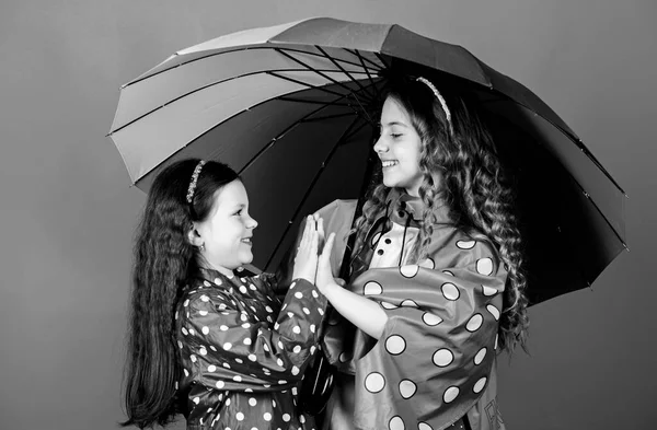 Vrolijke hippe kinderen, zusterschap. regenbescherming. Regenboog. familiebanden. Kleine meisjes in regenjas. gelukkige kleine meisjes met kleurrijke paraplu. Herfst mode. Zorgeloze ochtend — Stockfoto