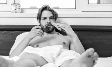 Büyük çıplak kaslı adam yatak odasında eğleniyor. Yatak odasında cep telefonuyla uyandırılan uyuyan adam. Günün güzel bir başlangıcı. Kupadan içmek..