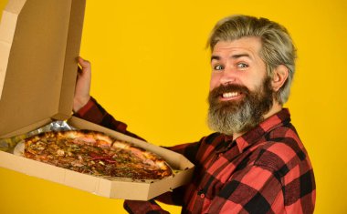 Aç adam tek başına pizza yiyecek. Evlere yemek gönderin. Daireye yemek götürüyorum. Taze ve sıcak. Canım İtalyan yemeği çekti. Sakallı hippi adam elinde karton pizza kutusu tutuyor. Pizza teslimat servisi.