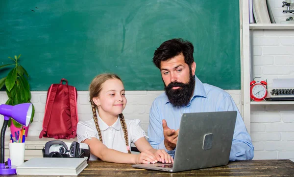 Study modern technologies. School teacher and schoolgirl with laptop. Man bearded pedagogue teaching informatics. Homeschooling with father. Find buddy to help you study. Private lesson. Study online