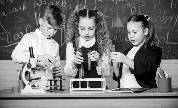 Formalna edukacja. Laboratorium szkolne. Uczniowie szkolni badają płyny chemiczne. Dziewczyny i chłopcy przeprowadzają szkolne eksperymenty z płynami. Lekcja chemii. Lampy testowe z substancjami — Zdjęcie stockowe