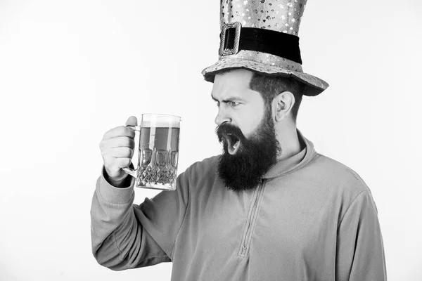 Irlandês até eu desmaiar. Hipster de chapéu de duende segurando caneca de cerveja. Um irlandês com barba a beber cerveja verde. Homem barbudo a brindar ao dia dos santos patricks. Celebrando dia de santo patricks no bar — Fotografia de Stock
