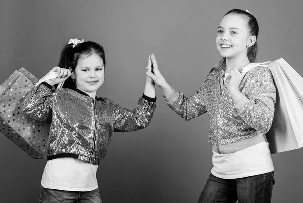 Porque a imagem é tudo. Compras e compras. Sexta-feira negra. Venda e desconto. Dia das compras. Pacotes de crianças. Moda infantil. Meninas irmãs amigos com sacos de compras fundo violeta — Fotografia de Stock