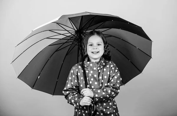 子供の女の子幸せカラフルな虹の傘を保持します。適切な衣服で雨の天気。雨の日の楽しみ。傘の下で幸せな散歩。雨の後はいつも虹があります。雨のコンセプトをお楽しみください。秋 — ストック写真
