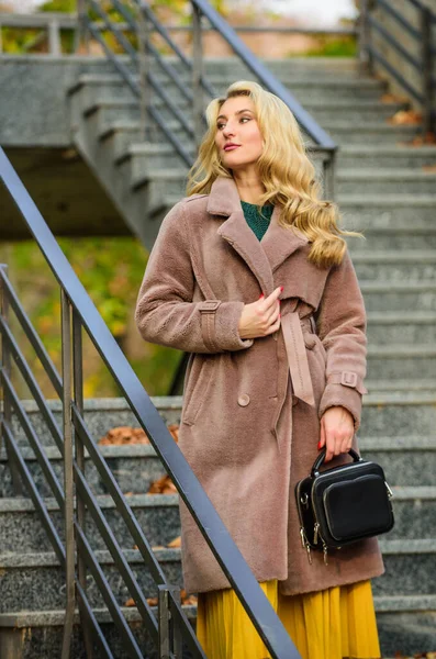 Feeling cold. sexy blong woman. autumn season. european winter. girl warm coat stairs background. faux fur coat fashion. stylish business lady leather bag. glamour girl look luxuriously — Stock Photo, Image