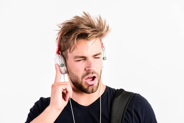 学生帅哥听音乐。节奏旋律的概念。下载音乐应用程序。男人乱蓬蓬的发型戴着塑料耳机小玩意.去哪儿就去哪儿欣赏音乐。青春音乐品味 — 图库照片