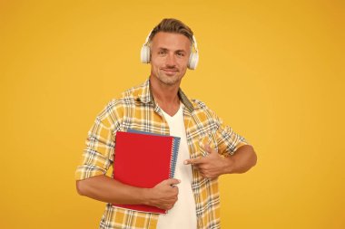 İngilizce öğreniyorum. Eğitim teknolojisi. Çalış. Ses kitabı konsepti. Dünya çapında bilgi erişimi. Ses kütüphanesi. Başka bir çalışma şekli. Yakışıklı üniversite öğrencisi kulaklıkları. Dil çalış