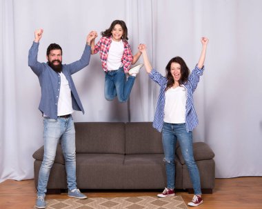 Yeni eve taşın. Enerji dolu. çocukluk mutluluğu. Mutlu aile günleri. Birlikte vakit geçirmek. Mutlu insanlar özgürlük hissinden atlarlar. Anne baba ve kızı evde eğleniyorlar. Daha iyi yaşamak