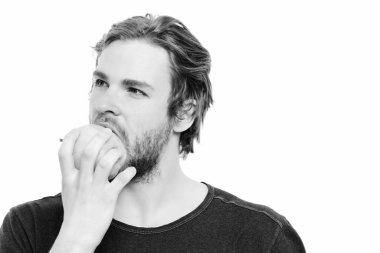 Seksi bakışlı, düşünceli, yeşil elmayı ısıran bir adam.